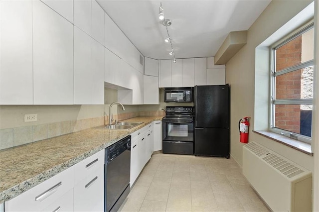 kitchen with black appliances, radiator heating unit, a sink, white cabinetry, and light tile patterned floors
