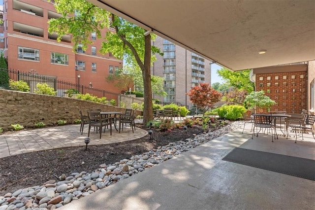 view of patio with outdoor dining space and fence