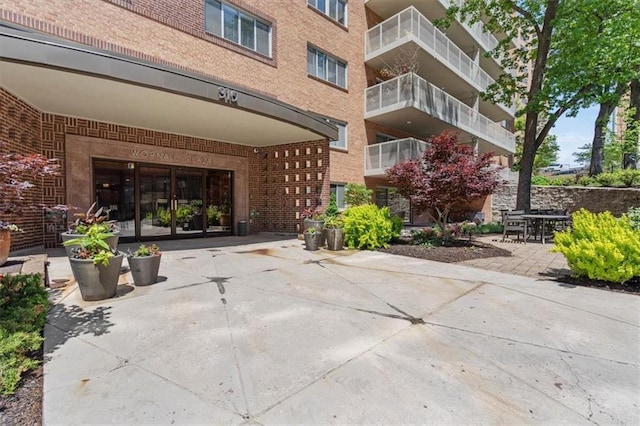 view of exterior entry featuring brick siding and french doors