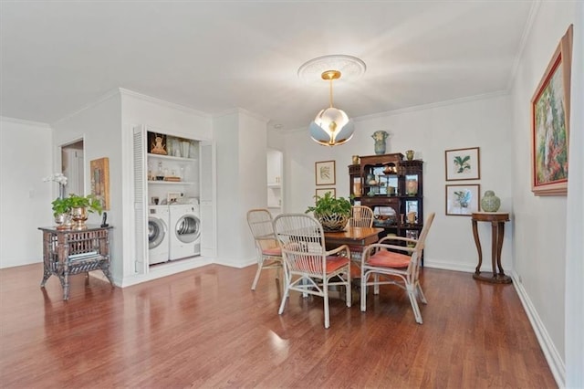 dining room featuring washing machine and dryer, wood finished floors, and ornamental molding