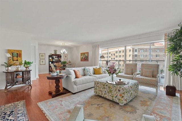 living room featuring crown molding, wood finished floors, and baseboards