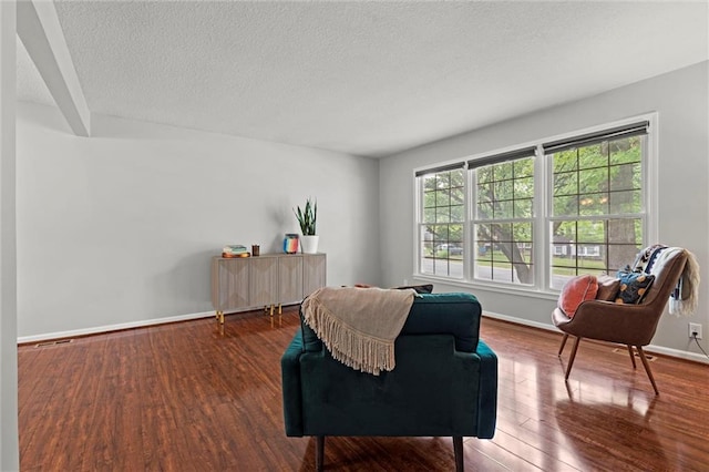 sitting room featuring wood finished floors, a textured ceiling, and baseboards