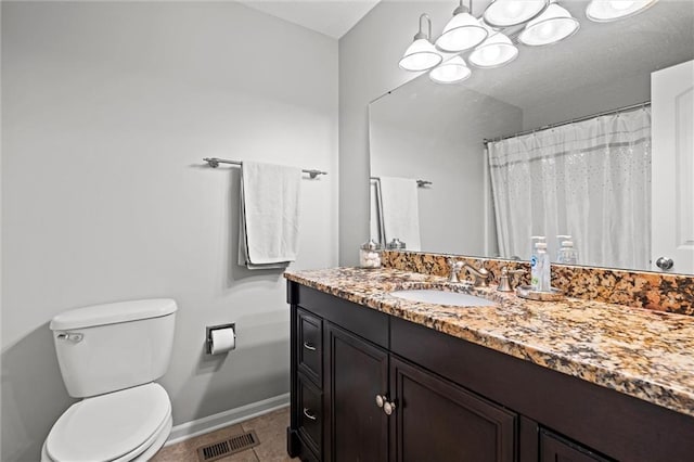 bathroom featuring tile patterned floors, toilet, vanity, and a chandelier