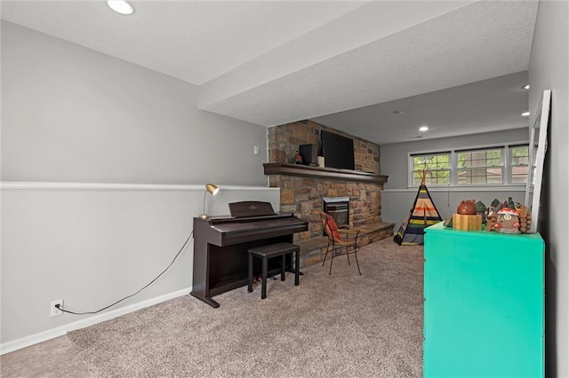 playroom with carpet flooring, baseboards, a stone fireplace, and recessed lighting