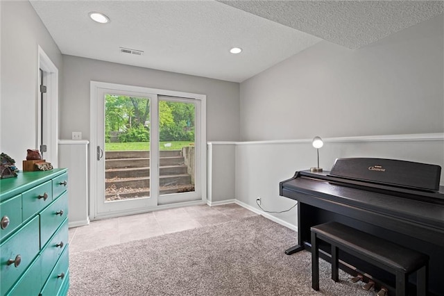 living area with carpet, a textured ceiling, recessed lighting, baseboards, and tile patterned floors