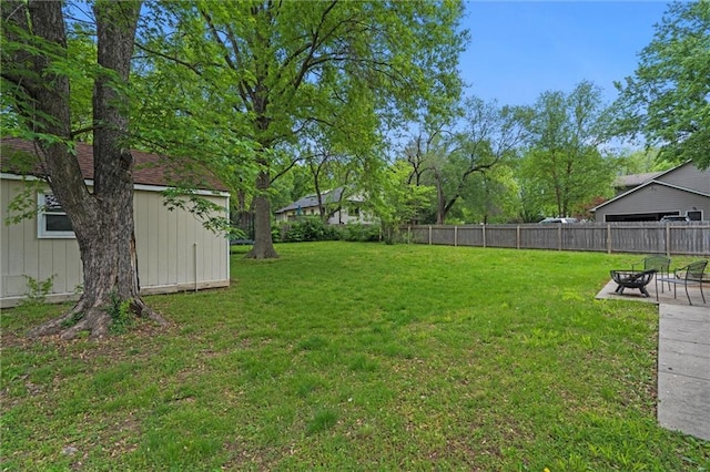 view of yard featuring an outdoor fire pit, an outdoor structure, a patio, and a shed