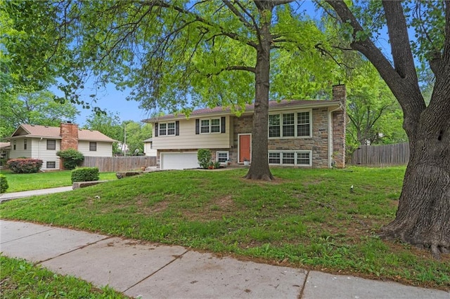 raised ranch with a chimney and an attached garage