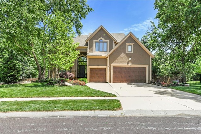 12843 Noland St, Overland Park, KS 66213 - view of front of home with stucco siding, driveway, and a garage