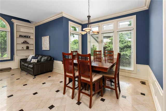 12843 Noland St, Overland Park, KS 66213 - dining room featuring a chandelier, built in shelves, healthy amount of natural light, ornamental molding, and a decorative wall