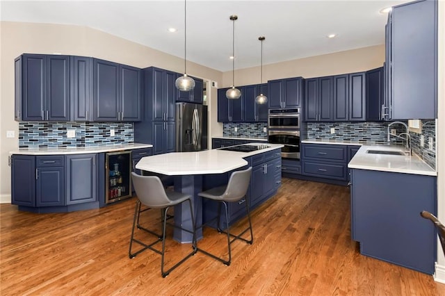 12843 Noland St, Overland Park, KS 66213 - kitchen featuring stainless steel appliances, a kitchen island, decorative backsplash, blue cabinets, and recessed lighting