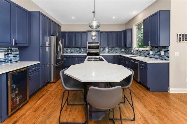 12843 Noland St, Overland Park, KS 66213 - kitchen featuring beverage cooler, appliances with stainless steel finishes, backsplash, a center island, and blue cabinets