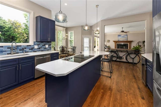 12843 Noland St, Overland Park, KS 66213 - kitchen with blue cabinetry, appliances with stainless steel finishes, a breakfast bar, light countertops, and recessed lighting