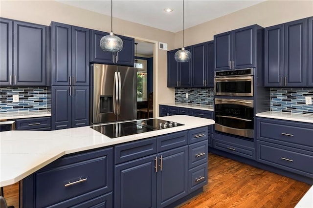 12843 Noland St, Overland Park, KS 66213 - kitchen with stainless steel appliances, blue cabinetry, tasteful backsplash, pendant lighting, and recessed lighting