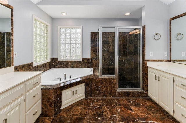 12843 Noland St, Overland Park, KS 66213 - full bathroom featuring marble tiled floors, two vanities, a garden tub, a stall shower, and recessed lighting
