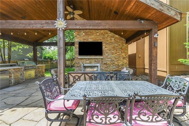 12843 Noland St, Overland Park, KS 66213 - view of patio featuring an outdoor stone fireplace, exterior kitchen, outdoor dining space, ceiling fan, and a gazebo
