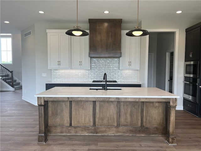 kitchen featuring stainless steel appliances, premium range hood, decorative backsplash, dark wood-style floors, and recessed lighting