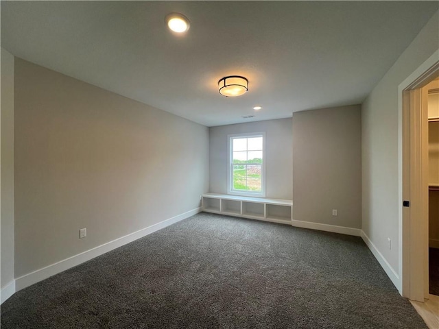 empty room featuring baseboards, dark colored carpet, and recessed lighting
