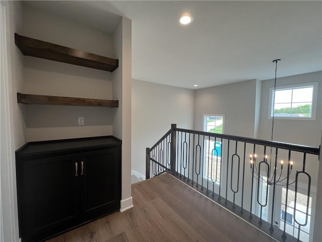 hallway featuring dark wood-type flooring, plenty of natural light, an upstairs landing, recessed lighting, and baseboards