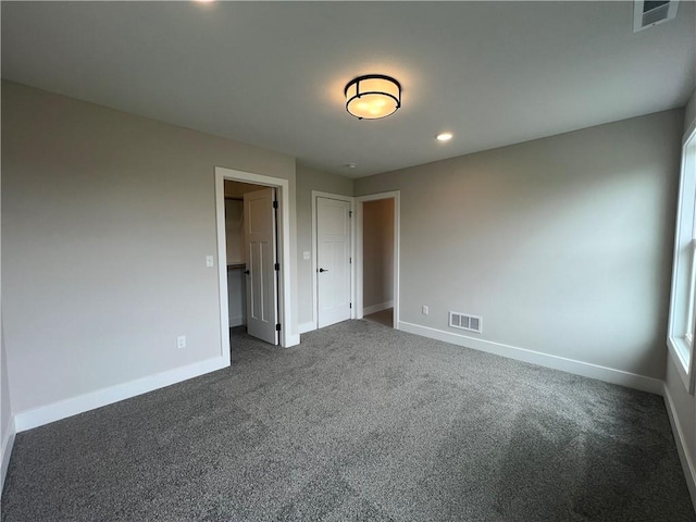 unfurnished bedroom with baseboards, dark colored carpet, recessed lighting, and a closet