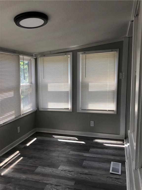 2063 Springfield Blvd, Kansas City, KS 66101 - empty room featuring dark wood-style floors and baseboards