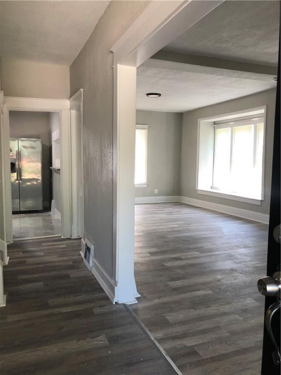 2063 Springfield Blvd, Kansas City, KS 66101 - hallway featuring dark wood-style flooring and baseboards