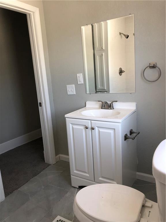 2063 Springfield Blvd, Kansas City, KS 66101 - bathroom featuring toilet, vanity, and baseboards