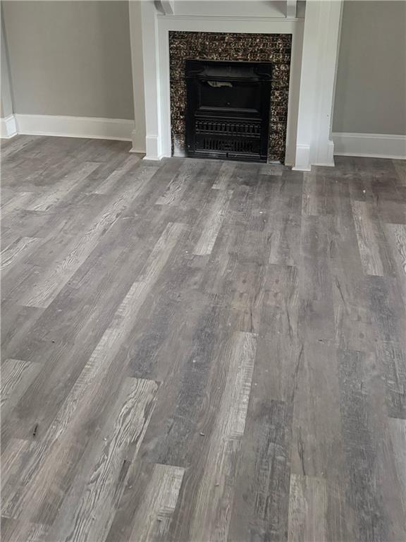 2063 Springfield Blvd, Kansas City, KS 66101 - detailed view of wood finished floors, baseboards, and a fireplace