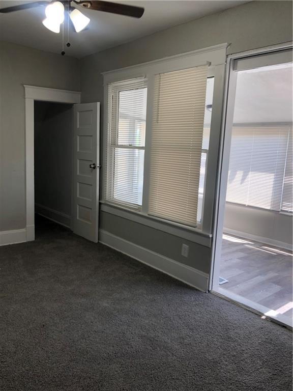 2063 Springfield Blvd, Kansas City, KS 66101 - unfurnished room featuring dark carpet, ceiling fan, and baseboards
