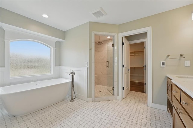 11588 S Houston St, Olathe, KS 66061 - full bath with a stall shower, a freestanding tub, a walk in closet, vanity, and a wainscoted wall