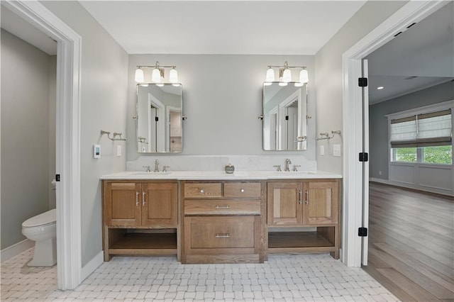 11588 S Houston St, Olathe, KS 66061 - full bathroom with double vanity, toilet, baseboards, and wood finished floors