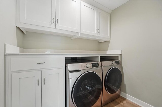 11588 S Houston St, Olathe, KS 66061 - laundry room with washer and clothes dryer, baseboards, cabinet space, and light wood-style floors