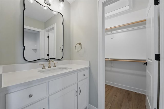 11588 S Houston St, Olathe, KS 66061 - bathroom featuring wood finished floors, a walk in closet, vanity, and baseboards
