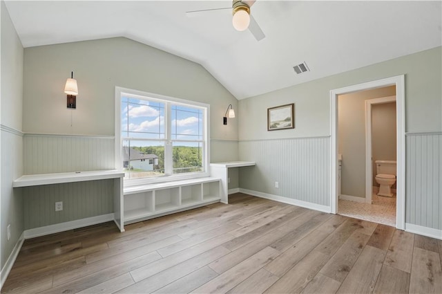 11588 S Houston St, Olathe, KS 66061 - unfurnished bedroom featuring wood finished floors, a wainscoted wall, vaulted ceiling, and a ceiling fan