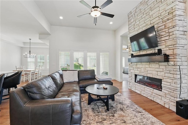24765 W 89th Ter, Lenexa, KS 66227 - living room with a ceiling fan, a fireplace, wood finished floors, a chandelier, and recessed lighting