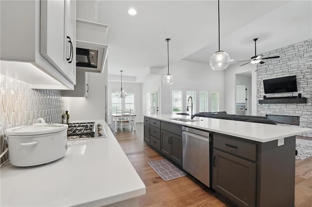 24765 W 89th Ter, Lenexa, KS 66227 - kitchen featuring dishwasher, a sink, light countertops, wood finished floors, and open floor plan