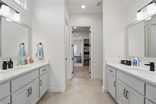 24765 W 89th Ter, Lenexa, KS 66227 - bathroom with two vanities, baseboards, a walk in closet, and recessed lighting