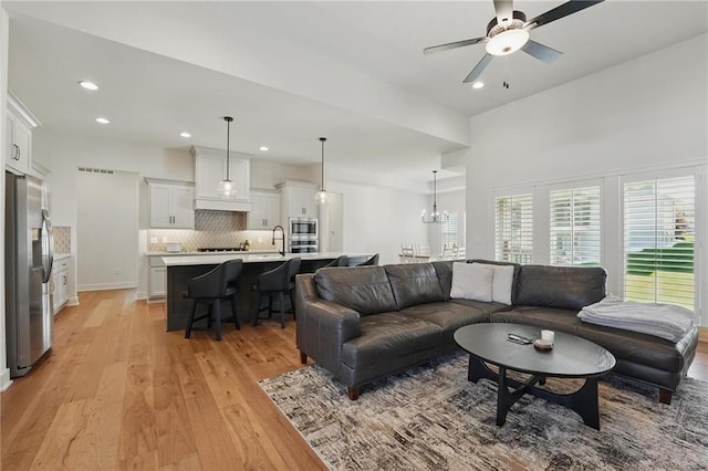 24765 W 89th Ter, Lenexa, KS 66227 - living room with light wood-style flooring, a ceiling fan, recessed lighting, and a chandelier