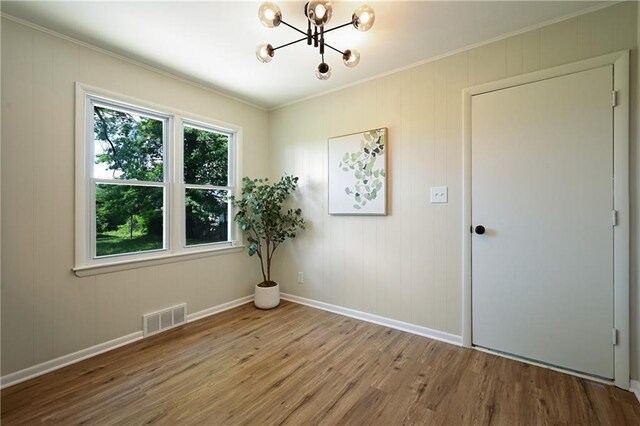 11524 Sunnyslope Dr, Kansas City, MO 64134 - empty room featuring wood finished floors, ornamental molding, a chandelier, and baseboards