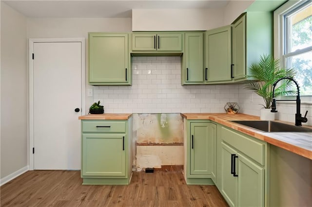 11524 Sunnyslope Dr, Kansas City, MO 64134 - kitchen featuring green cabinets, wooden counters, a sink, tasteful backsplash, and light wood finished floors