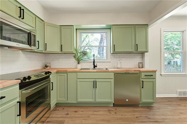 11524 Sunnyslope Dr, Kansas City, MO 64134 - kitchen with green cabinets, appliances with stainless steel finishes, a sink, and wooden counters