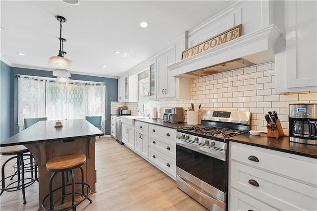 9849 Riggs St, Overland Park, KS 66212 - kitchen featuring appliances with stainless steel finishes, dark countertops, a kitchen breakfast bar, white cabinetry, and ornamental molding