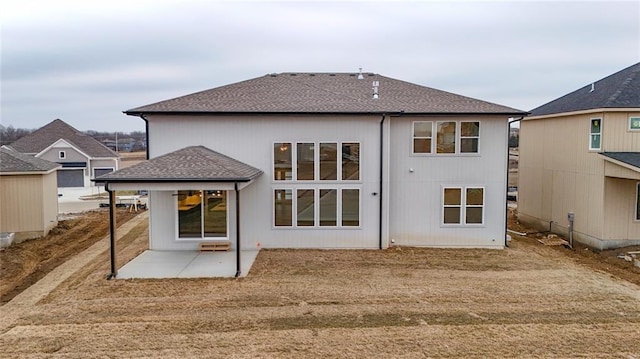 back of property featuring a patio and a shingled roof