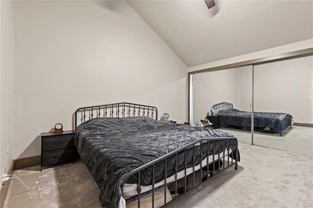 bedroom featuring carpet floors, vaulted ceiling, baseboards, a closet, and ceiling fan
