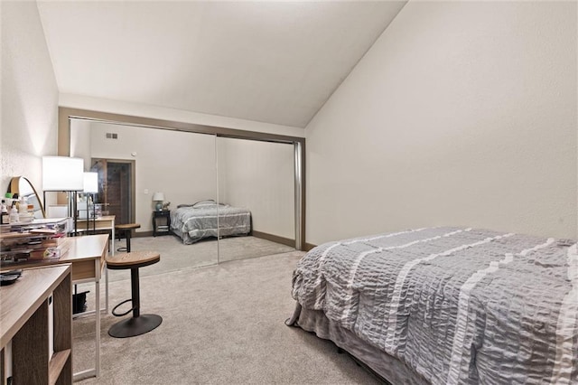 bedroom with carpet floors, lofted ceiling, and a closet