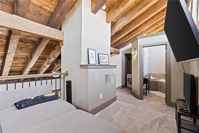 carpeted bedroom with wood ceiling, ensuite bathroom, washer / dryer, and baseboards