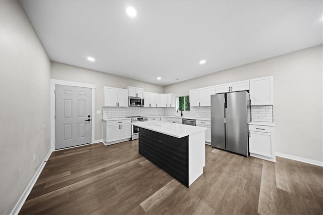 6339 Harris Ave, Raytown, MO 64133 - kitchen featuring appliances with stainless steel finishes, light countertops, decorative backsplash, dark wood-style flooring, and recessed lighting