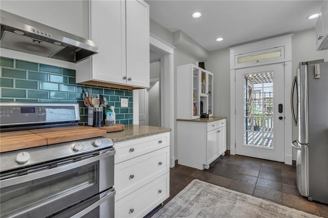 605 W 59th Ter, Kansas City, MO 64113 - kitchen featuring appliances with stainless steel finishes, wall chimney range hood, white cabinetry, tasteful backsplash, and recessed lighting