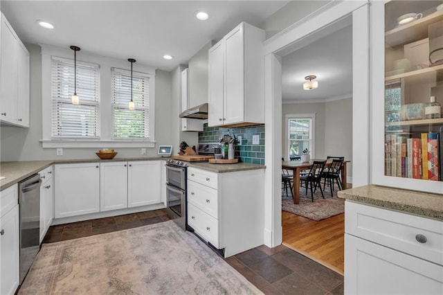 605 W 59th Ter, Kansas City, MO 64113 - kitchen featuring appliances with stainless steel finishes, exhaust hood, stone tile floors, white cabinetry, and hanging light fixtures