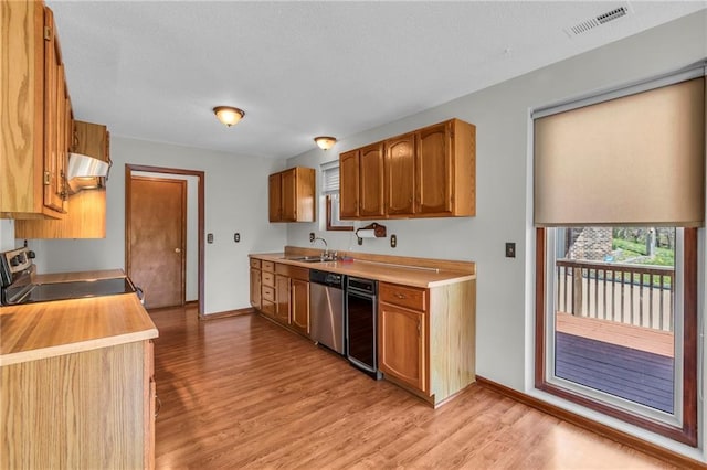 kitchen with appliances with stainless steel finishes, extractor fan, light wood-type flooring, and baseboards