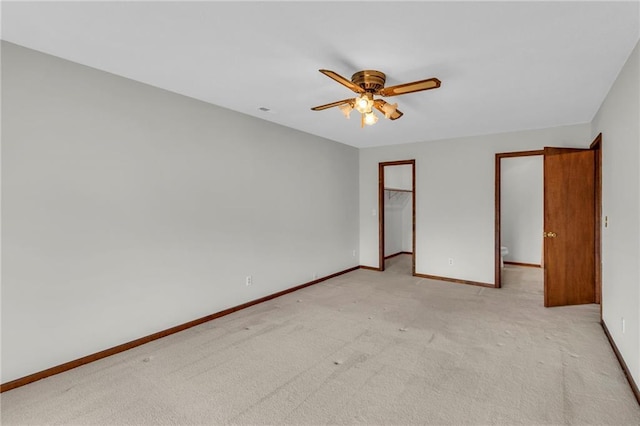 spare room with ceiling fan, baseboards, and light carpet